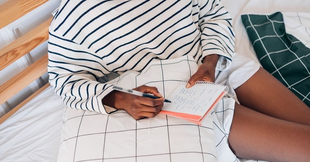 unrecognizable-woman-sitting-in-bed-writing-journal-notebook-1200×628-facebook